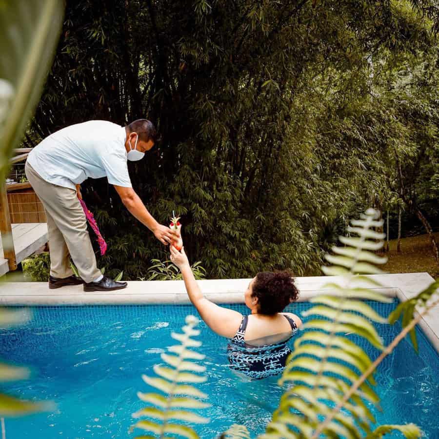 chaa creek belize resort staff serving guest drink in personal plunge pool