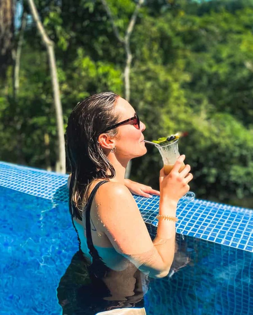 6 reasons to travel to Belize this summer woman drinking cocktail in pool